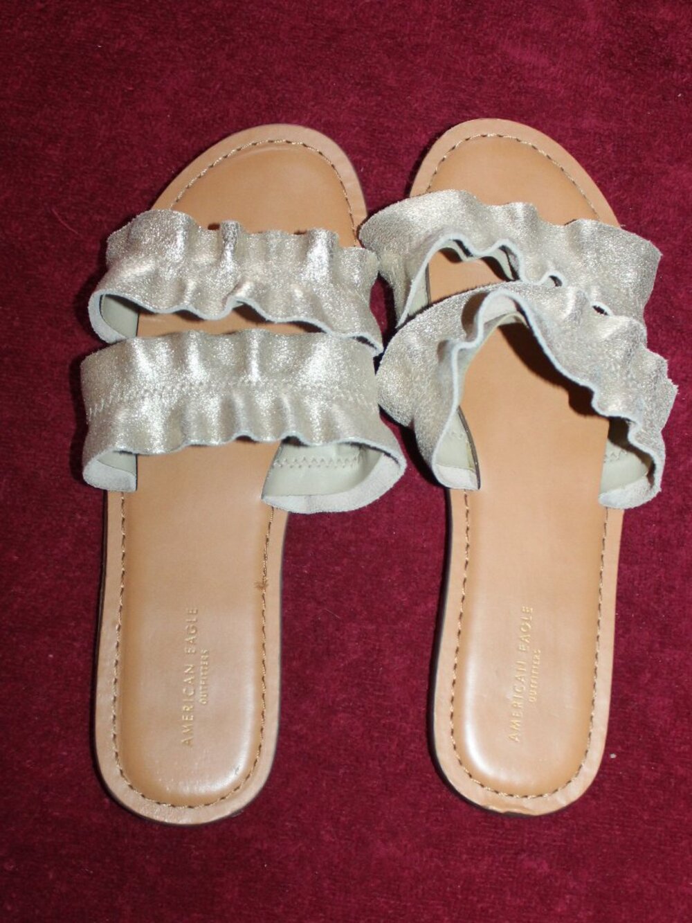 American Eagle Outfitters metallic gold double-strap ruffle slide sandals.